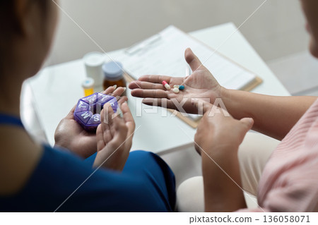 A woman is holding a pill bottle and a pill organizer A woman is holding a pill bottle and a pill organizer 136058071