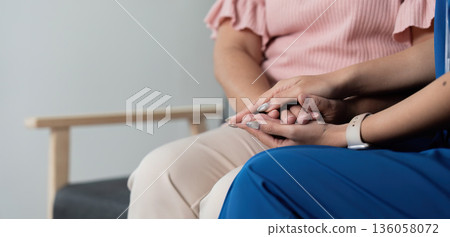 A woman is holding hands with another woman A woman is holding hands with another woman 136058072