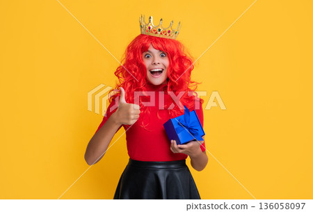 glad amazed child in diadem with present box on yellow background glad amazed child in diadem with present box on yellow background 136058097