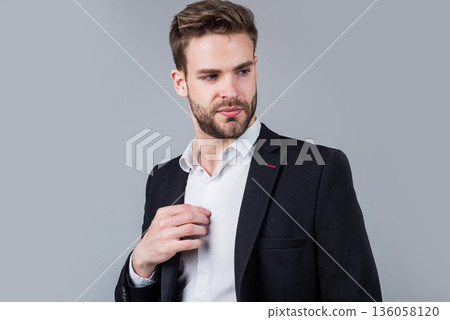 Feeling flirty. Young manager in his office. portrait of a businessman on grey background. confident businessman portrait. Portrait of a handsome CEO. Businessman in suit. Young handsome man 136058120