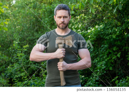 photo of man hold ax. man with ax. man with ax wearing shirt. man with ax outdoor 136058135