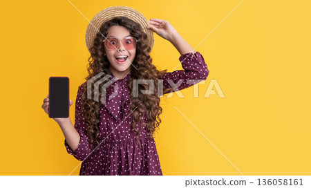 amazed child with curly hair presenting screen of smartphone with copy space amazed child with curly hair presenting screen of smartphone with copy space 136058161