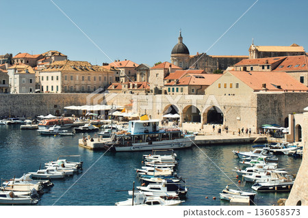 View of the yacht harbour in the old town port of Dubrovnik, with the dome tower of the Cathedral of the Assumption of the Virgin Mary visible in the distance 136058573