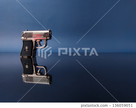 Toy model of a small pocket pistol with reflection on a dark blue background. Toy model of a small pocket pistol with reflection on a dark blue background. 136059051