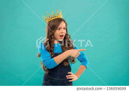 Hey you. Kid wear golden crown symbol of princess. Girl cute outraged expression baby wear crown blue background. Childhood concept. Every girl dreaming to become princess. Lady little princess Hey you. Kid wear golden crown symbol of princess. Girl cute outraged expression baby wear crown blue background. Childhood concept. Every girl dreaming to become princess. Lady little princess 136059099
