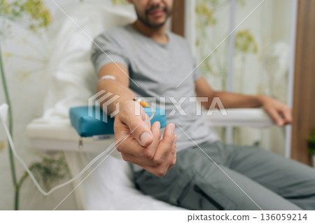 Patient receiving intravenous infusion treatment through iv drip on their arm, focusing on healthcare, medicine, medical therapy, and vitamin benefits in clinic setting. Concept of healthy lifestyle. Patient receiving intravenous infusion treatment through iv drip on their arm, focusing on healthcare, medicine, medical therapy, and vitamin benefits in clinic setting. Concept of healthy lifestyle. 136059214