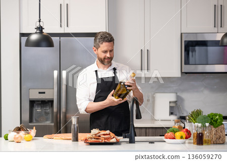 Healthy food diet. Man cook tasty meal. Home menu with seafood food. Man cook cooking at kitchen. Hispanic man standing in kitchen preparing sea food. Man cook tasty crab leg. Seafood feast Healthy food diet. Man cook tasty meal. Home menu with seafood food. Man cook cooking at kitchen. Hispanic man standing in kitchen preparing sea food. Man cook tasty crab leg. Seafood feast 136059270