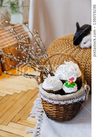 Easter basket with kulich cakes and white bunnies on cozy spring background Easter basket with kulich cakes and white bunnies on cozy spring background 136059286