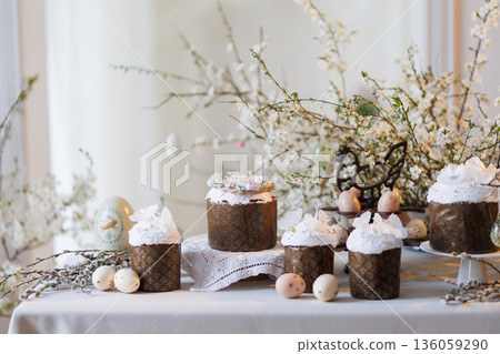 Easter cakes and painted eggs on spring table with blossom branches Easter cakes and painted eggs on spring table with blossom branches 136059290