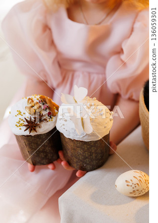 Child holding decorated Easter cakes with icing and painted egg on table Child holding decorated Easter cakes with icing and painted egg on table 136059301