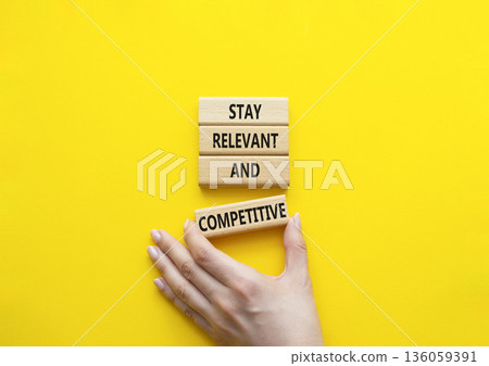 Relevant and Competitive symbol. Concept words Stay Relevant and Competitive on wooden blocks. Beautiful bright yellow background. Businessman hand. Business and Stay Relevant and Competitive concept. Relevant and Competitive symbol. Concept words Stay Relevant and Competitive on wooden blocks. Beautiful bright yellow background. Businessman hand. Business and Stay Relevant and Competitive concept. 136059391