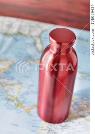 Red water bottle and paper map 136059434