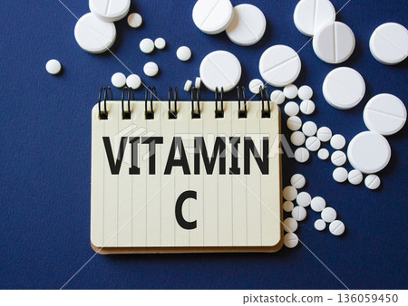 Vitamin C symbol. Concept word Vitamin C on notebook. Beautiful deep blue background with pills. Medicine and Vitamin C concept. Copy space 136059450