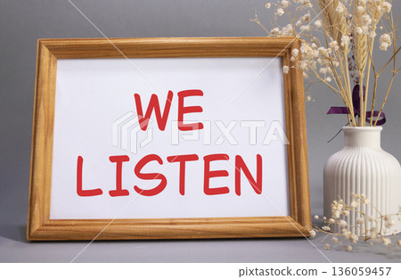 We listen symbol. Concept words We listen on beautiful wooden picture frame. Beautiful grey background with flower vase. Business and We listen concept. Copy space. We listen symbol. Concept words We listen on beautiful wooden picture frame. Beautiful grey background with flower vase. Business and We listen concept. Copy space. 136059457