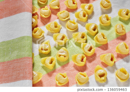 Uncooked tortellini pasta on colored cloth Uncooked tortellini pasta on colored cloth 136059463
