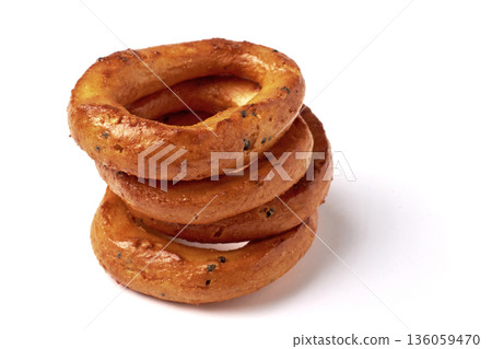 A balanced pyramid of salted pretzels with poppy seeds isolated on a white background. A balanced pyramid of salted pretzels with poppy seeds isolated on a white background. 136059470