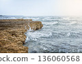 Rocky coastline with waves crashing against the shore.  136060568