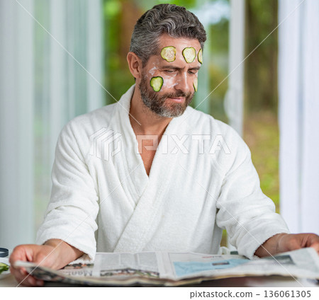 Hispanic man with facial cucumber mask. Benefits of vitamin C. Man applying facial mask cucumber. Face treatment. Facial mask of cucumber. Cosmetic procedure man with cucumber slices mask on face Hispanic man with facial cucumber mask. Benefits of vitamin C. Man applying facial mask cucumber. Face treatment. Facial mask of cucumber. Cosmetic procedure man with cucumber slices mask on face 136061305