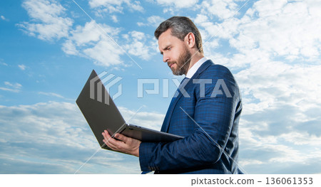 caucasian freelancer man with laptop wearing suit. photo of freelancer man with laptop. 136061353