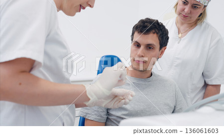 Dentist explaining invisalign treatment to patient 136061603