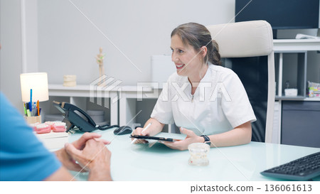 Dentist woman discussing treatment plan with patient Dentist woman discussing treatment plan with patient 136061613
