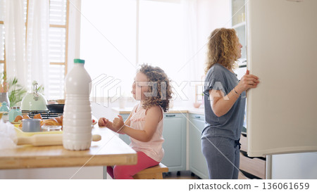 Mother and daughter preparing breakfast in kitchen Mother and daughter preparing breakfast in kitchen 136061659