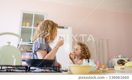 Mother and daughter having fun cooking breakfast 136061660