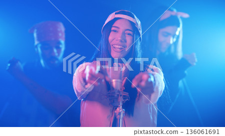 Female singer performing on stage with dancers Female singer performing on stage with dancers 136061691