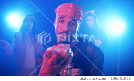 Male singer performing on stage with dancers Male singer performing on stage with dancers 136061692