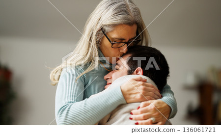 Mother kissing forehead of adult son with a disability Mother kissing forehead of adult son with a disability 136061721