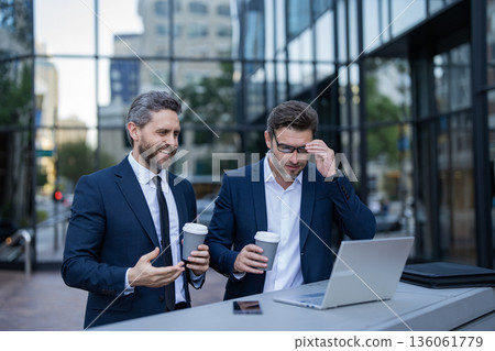 Businessmen investor trading business online working with laptop analyzing stock market outdoor Businessmen investor trading business online working with laptop analyzing stock market outdoor 136061779