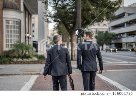 Walk of two business men. Colleague in New York. Success. Businessmen in suit walk outdoor. Walk to success. Two businessmen walk in the city. Business men crossing the street. Go to the new goals 136061785
