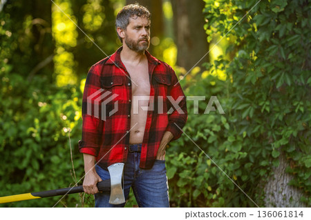 Man with logging axe. Brutal man in unbuttoned shirt. Lumberjack hardworking outdoor. Brutal lumberjack, copy space. Brutality and masculinity. Hispanic lumberjack man with axe. Lumberjack axe 136061814