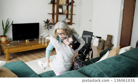Mother assisting young man with mobility needs at home Mother assisting young man with mobility needs at home 136061838