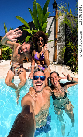 Happy friends enjoying summer vacation pool selfie Happy friends enjoying summer vacation pool selfie 136061849