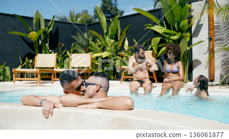 Gay couple kissing in swimming pool with friends Gay couple kissing in swimming pool with friends 136061877
