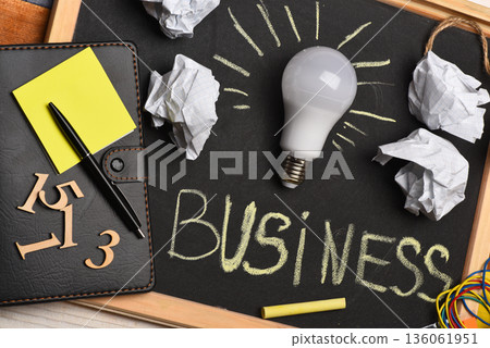 Chalkboard with wrinkled paper, notepad, pen, numerals and lamp. Chalkboard with wrinkled paper, notepad, pen, numerals and lamp. 136061951