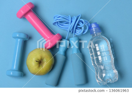 Jump rope, apple and barbells next to water bottle Jump rope, apple and barbells next to water bottle 136061963