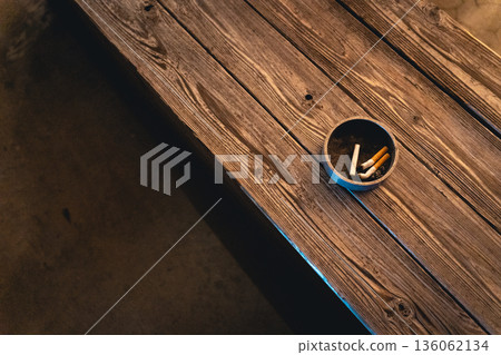 Cigarette ashtray on a bench at night 136062134