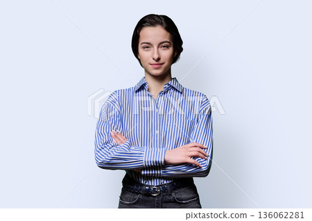 Portrait of smiling young confident girl looking at camera on white background 136062281