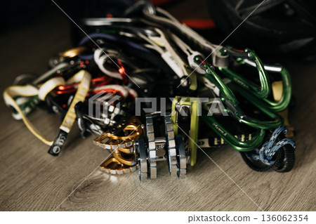 Traditional Rock Climbing Gear On Wooden Surface: Friends, Quick Draws, Cams, And Carabiners Arranged As Safety Protection Equipment In Detailed Close Up Traditional Rock Climbing Gear On Wooden Surface: Friends, Quick Draws, Cams, And Carabiners Arranged As Safety Protection Equipment In Detailed Close Up 136062354