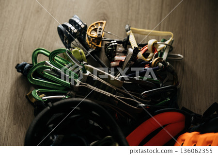 Traditional Rock Climbing Gear On Wooden Surface: Friends, Quick Draws, Cams, And Carabiners Arranged As Safety Protection Equipment In Detailed Close Up Traditional Rock Climbing Gear On Wooden Surface: Friends, Quick Draws, Cams, And Carabiners Arranged As Safety Protection Equipment In Detailed Close Up 136062355