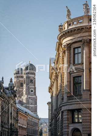 Historic Munich Old Town Street With Cathedral Of Our Dear Lady: Narrow Urban Alley Framing Iconic Twin Domed Church Towers And Traditional Bavarian Architecture Historic Munich Old Town Street With Cathedral Of Our Dear Lady: Narrow Urban Alley Framing Iconic Twin Domed Church Towers And Traditional Bavarian Architecture 136062364