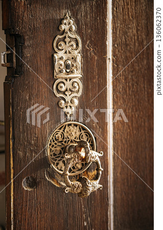 Ornate Antique Door Lock On Wooden Door: Decorative Metal Keyhole Plate And Vintage Craftsmanship In Historic Architectural Detail Ornate Antique Door Lock On Wooden Door: Decorative Metal Keyhole Plate And Vintage Craftsmanship In Historic Architectural Detail 136062370