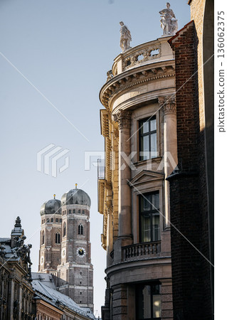 Historic Munich Old Town Street With Cathedral Of Our Dear Lady: Narrow Urban Alley Framing Iconic Twin Domed Church Towers And Traditional Bavarian Architecture 136062375