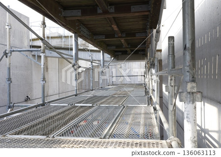 建築工地上搭建的鷹架走道正在進行施工。 建築工地上搭建的鷹架走道正在進行施工。 136063113