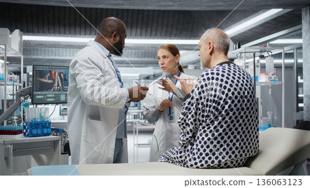 Diverse scientists performing observation and examination of a patient in a research lab, testing a new treatment and analyzing dosage effects. Studying risks and outcomes for progress. Camera A. Diverse scientists performing observation and examination of a patient in a research lab, testing a new treatment and analyzing dosage effects. Studying risks and outcomes for progress. Camera A. 136063123