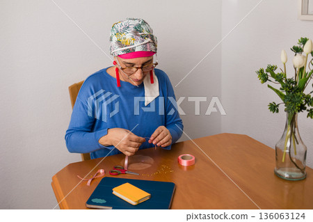 Woman crafting pink ribbons for breast cancer awareness Woman crafting pink ribbons for breast cancer awareness 136063124