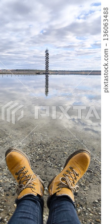 A perspective view of the lake and the tower from the side of the man in yellow boots A perspective view of the lake and the tower from the side of the man in yellow boots 136063488