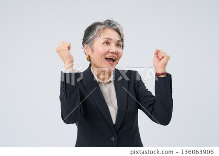 一位身著西裝的老年女性擺姿勢以示支持 一位身著西裝的老年女性擺姿勢以示支持 136063906